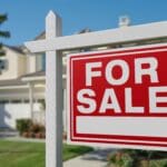 For,Sale,Real,Estate,Sign,In,Front,Of,Beautiful,House.
